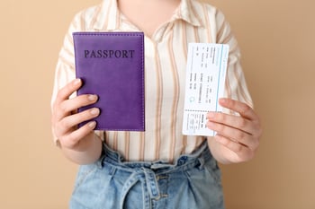 Person holding passport and ticket