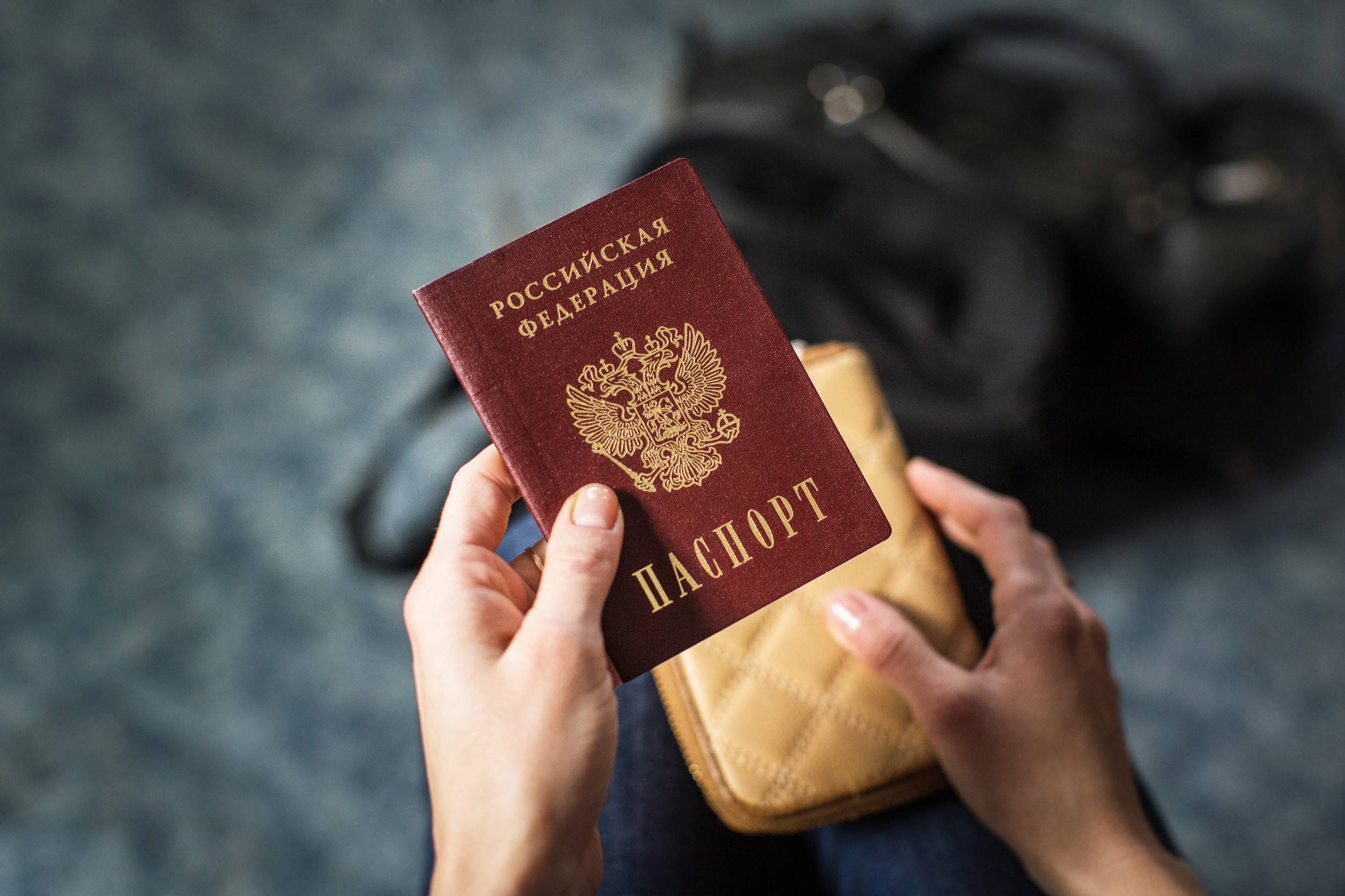 girl holding russian passport and purse