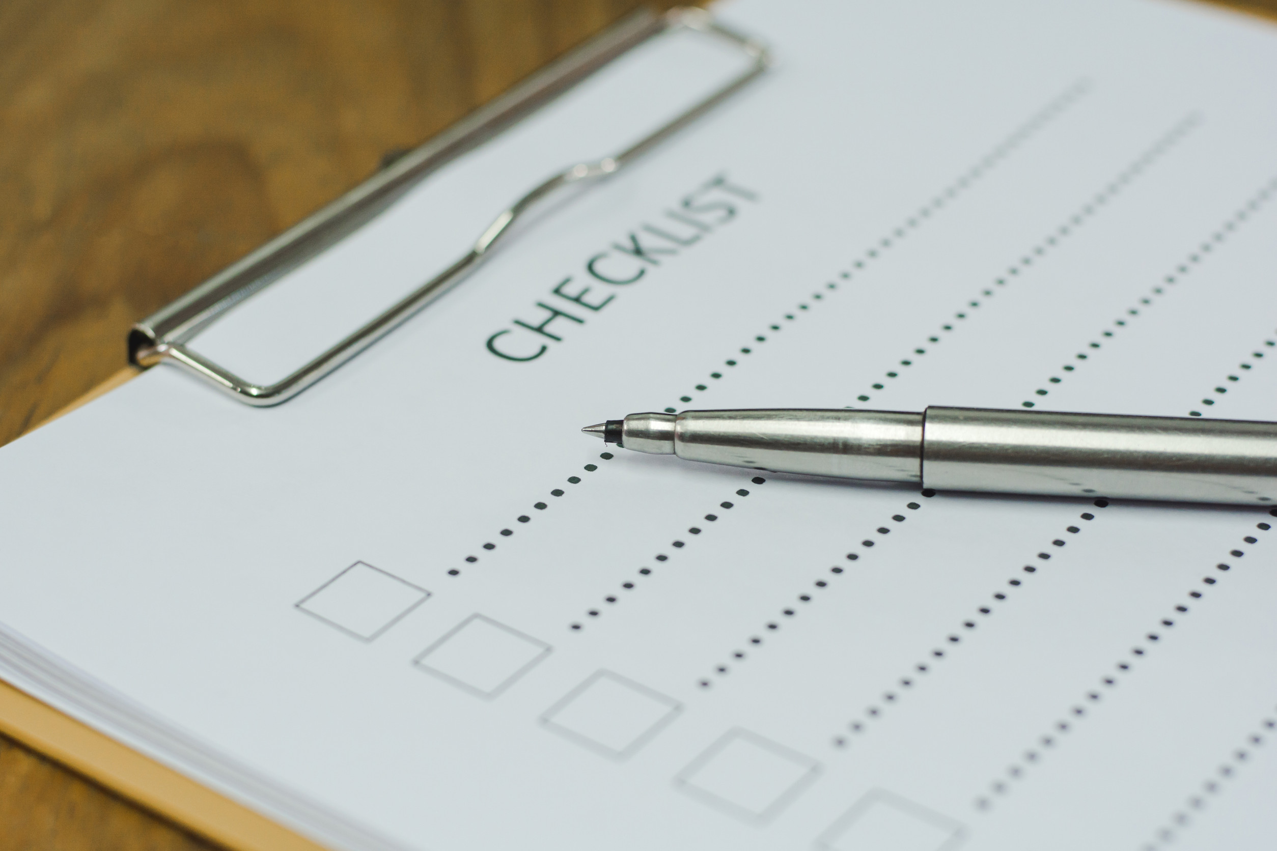 A checklist on a clipboard with a pen